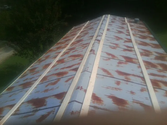 Rusted metal roof panels with new wood purlins before replacement — Storm Damage Roof Repair in Cusick by Roofing Brothers