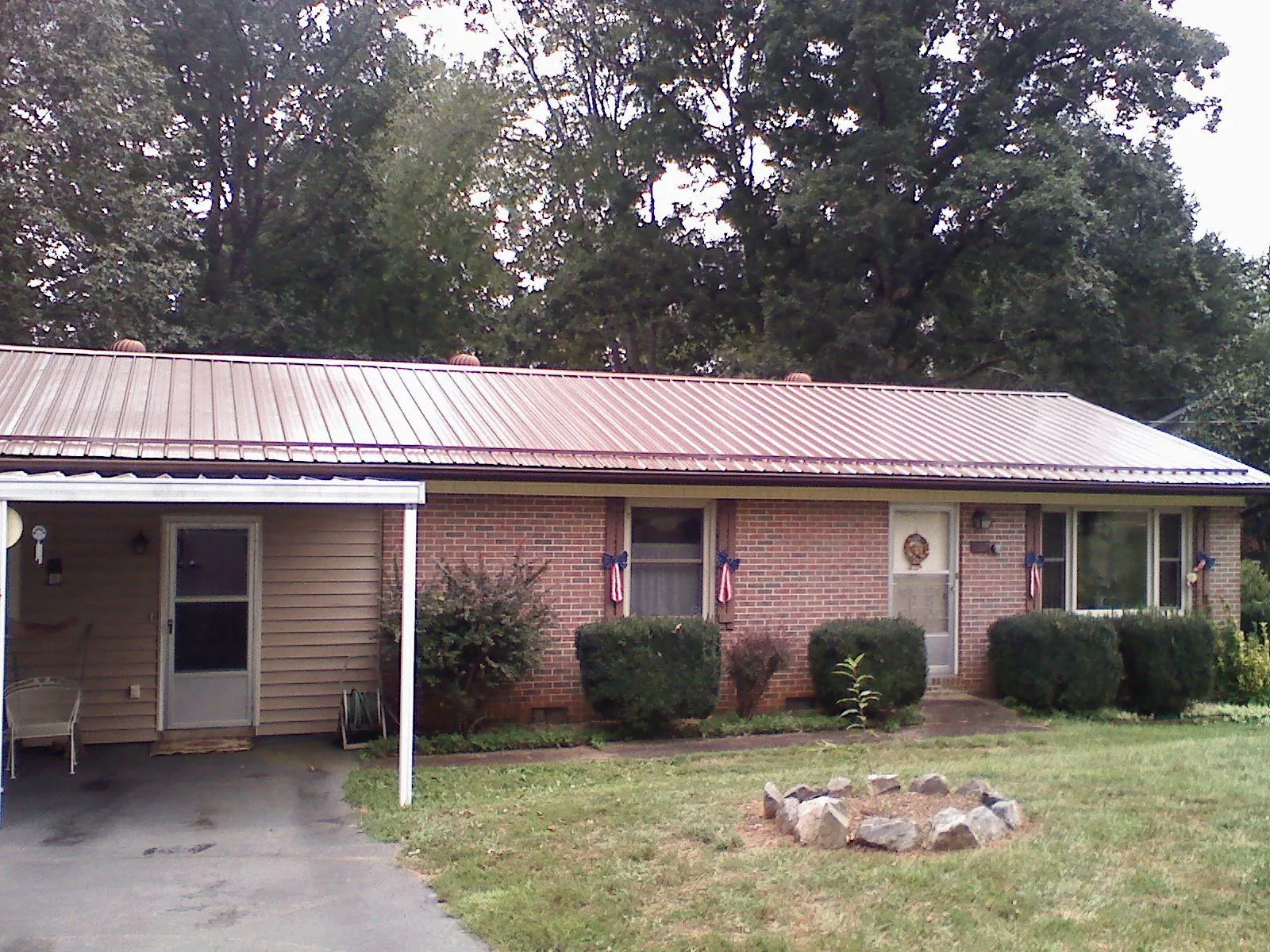 Bronze metal roof and carport on a brick ranch home — Roof Repair work by our crew in Cusick